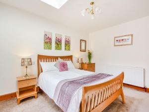 a bedroom with a large bed and a nightstand with a lamp at Fyvie Cottage in Banavie