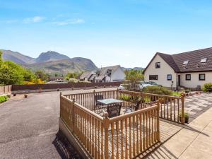 a balcony with a table and chairs and mountains at Fyvie Cottage in Banavie