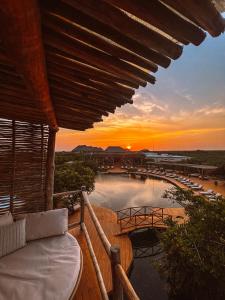 a sunset from a resort balcony with a pool at Hotel Shibari - Restaurant & Cenote Club in Tulum