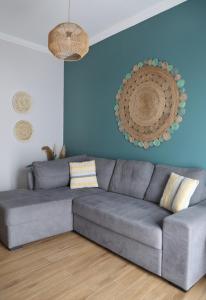 un divano grigio in un soggiorno con parete blu di Sitia Cozy Apartment a Sitia