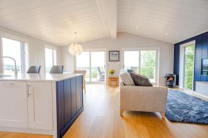 a kitchen and living room with a couch at Avocet Lodge in Ingoldisthorpe