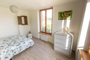 Schlafzimmer mit einem Bett und einem Fenster in der Unterkunft Maison La Cigogne Noire in La Loge-aux-Chèvres