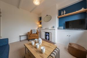 a living room with a table and a fireplace at Tide Cottage WR in West Runton