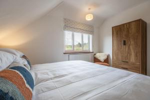 um quarto com uma grande cama branca e uma janela em Tide Cottage WR em West Runton