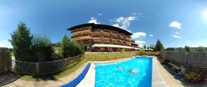 a pool at a resort with people swimming in it at Ferienhotel Knollhof in Ramsau am Dachstein
