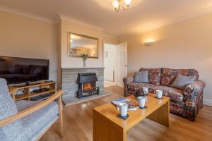 a living room with a couch and a fireplace at Arisaig in Wells next the Sea