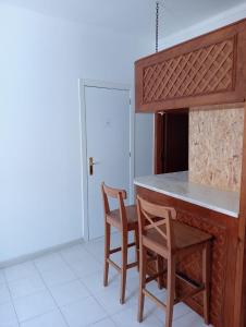 a kitchen with a counter and two chairs at Cacilhas Mini Hostel in Cacilhas