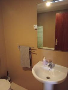 uma casa de banho com um lavatório, um espelho e um WC. em Cacilhas Mini Hostel em Cacilhas