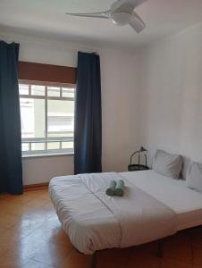 een slaapkamer met een bed met twee schoenen erop bij Cacilhas Mini Hostel in Cacilhas