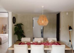 a dining room table with white chairs and a chandelier at Mr. W Park View Balcony Espana 602 in Mexico City