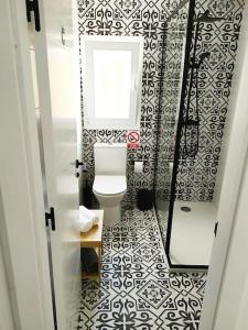 La salle de bains est pourvue de toilettes et de carrelage noir et blanc. dans l'établissement Casa Las Colinas, à Illana