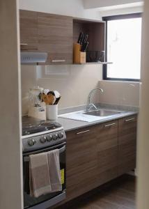 a small kitchen with a stove and a sink at Mr. W Park View Balcony Espana 602 in Mexico City