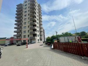 um edifício de apartamentos alto num parque de estacionamento em East View by DAT Apartments em Cluj-Napoca