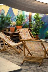 two wooden chairs sitting on a patio with plants at Backpackers Home in Zadar