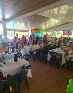 a group of people sitting at tables in a restaurant at Quinta privada con cabaña y piscina temperada in Cartago