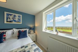 a bedroom with a bed and a large window at Sunset in Overstrand