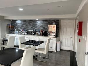 a kitchen with a black table and white chairs at Super 8 by Wyndham Mont Belvieu - Baytown East in Eldon