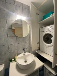 a bathroom with a sink and a washing machine at Rozos House in Loutsa +25 photos