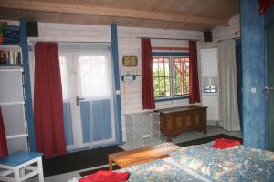 a bedroom with two beds and a desk and windows at Rotes Haus Usedom in Kamminke