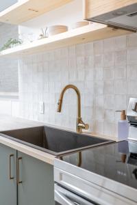 a kitchen with a black sink and white tiles at The Olympia: Front Street Flats in Belleville