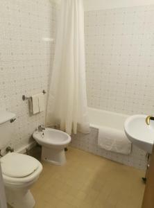 a bathroom with a toilet and a sink and a tub at Vivenda Alvor in Alvor