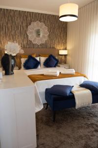 a bedroom with two beds with blue pillows at Casa das Caldas in Caldelas