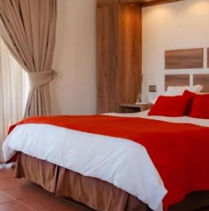 Un dormitorio con una cama roja y blanca con almohadas rojas en Pueblo Andaluz Olmué en Olmué