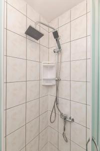 een douche met een douchekop in de badkamer bij Penzion ob Ribniku in Podlehnik