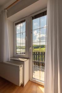 a room with a large window with a view at Penzion ob Ribniku in Podlehnik