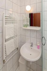 Baño blanco con lavabo y aseo en Penzion ob Ribniku en Podlehnik