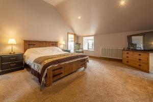 um quarto com uma cama, uma cómoda e um espelho em The Old English Barn em Bacton