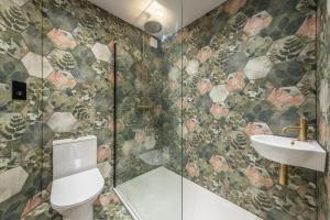 a bathroom with a toilet and a sink at Coach House Cottage in Weybourne +21 photos