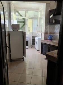 eine Küche mit einem großen Fenster und einem weißen Kühlschrank in der Unterkunft Agadir in Agadir