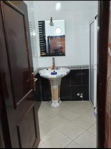 ein Badezimmer mit einem weißen Waschbecken und einem Spiegel in der Unterkunft Agadir in Agadir