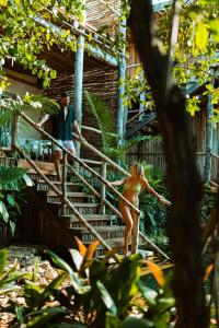 a man and woman walking down the stairs of a house at Hotel Shibari - Restaurant & Cenote Club in Tulum