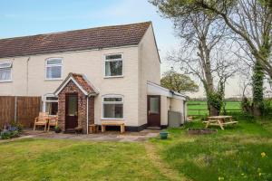 a house with a patio and a picnic table at Margarets Cottage in Potter Heigham