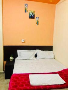 um quarto com uma cama com um cobertor vermelho em OYO The Bliss Guest House & Restaurant em Gwalior