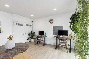 a living room with two tables and two monitors at Bodhi's sweet suite - Micro Studio - 91Walkscore in Seattle