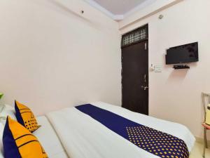 1 dormitorio con 1 cama y TV en la pared en Flagship Stay Inn en Kota