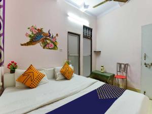 1 dormitorio con 1 cama grande con almohadas de color naranja y azul en Flagship Stay Inn en Kota
