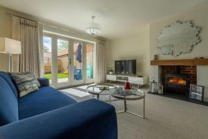 - un salon avec un canapé bleu et une cheminée dans l'établissement Long Meadow, à Great Bircham