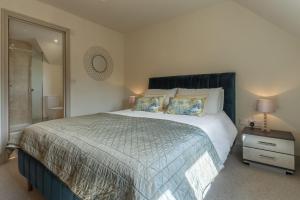 - une chambre avec un grand lit et un miroir dans l'établissement Long Meadow, à Great Bircham