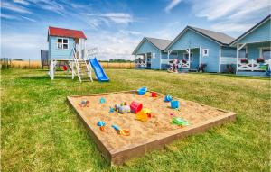 a sandbox in the middle of a yard with a house at Amazing Home In Jaroslawiec With House A Panoramic View in Jarosławiec