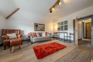 uma sala de estar com mobiliário e um tapete vermelho em The Hideaway em Great Massingham