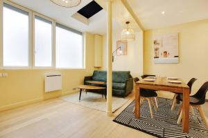 ein Wohnzimmer mit einem Tisch und einem Sofa in der Unterkunft New and bright apartment 4 people in Paris