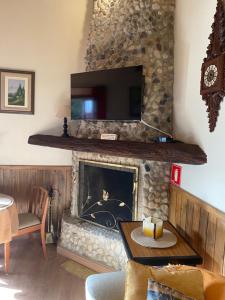 a living room with a fireplace with a tv above it at Chalé Recanto Bela Vista in Monte Verde