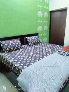 um quarto com uma cama com lençóis azuis e brancos em OYO Hotel Athiti 2 em Meerut