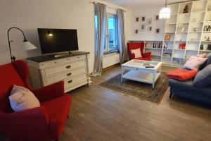 a living room with two couches and a tv at Ferienwohnung am Wald **** 