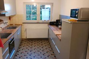 a kitchen with a refrigerator and a sink and a window at Ferienwohnung am Wald **** 