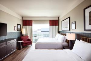 una habitación de hotel con 2 camas y una silla en The Scarlet, Lincoln, a Tribute Portfolio Hotel en Lincoln